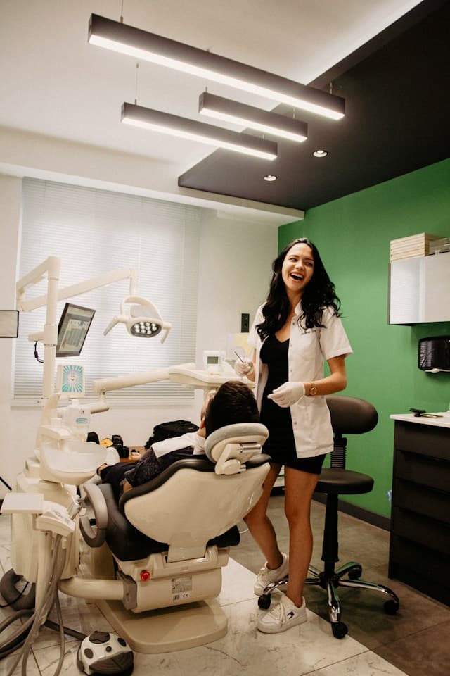 Smiling patient with two dental professionals