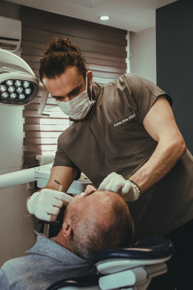 Two dentists treating a patient